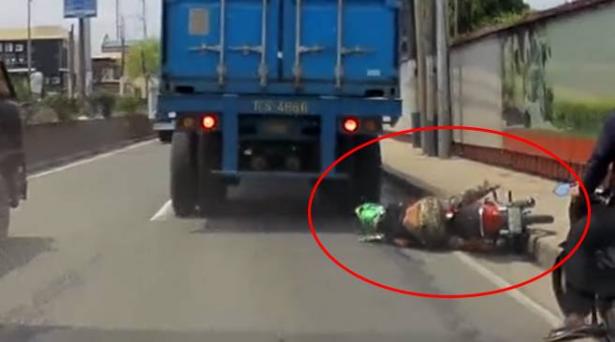 سائق دراجة نارية ينجو بأعجوبة بعد صعود شاحنة فوق رأسه (فيديو)
