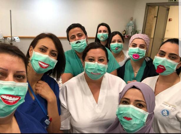 طاقم قسم الولادة في المستشفى الفرنسي يرتدون كمامات مع وجوه ضاحكة لنشر البهجة بين صفوف النساء