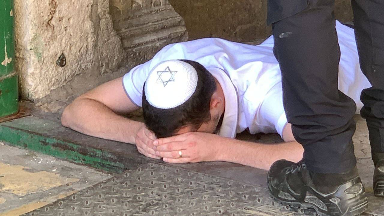 احد المستوطنين يؤدي الصلوات التلمودية على أبواب الأقصى 