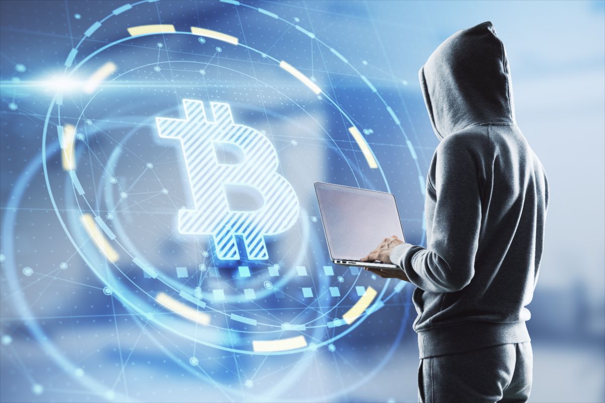 Hacker,In,Hoodie,Using,Laptop,Computer,With,Glowing,Bitcoin,Interface