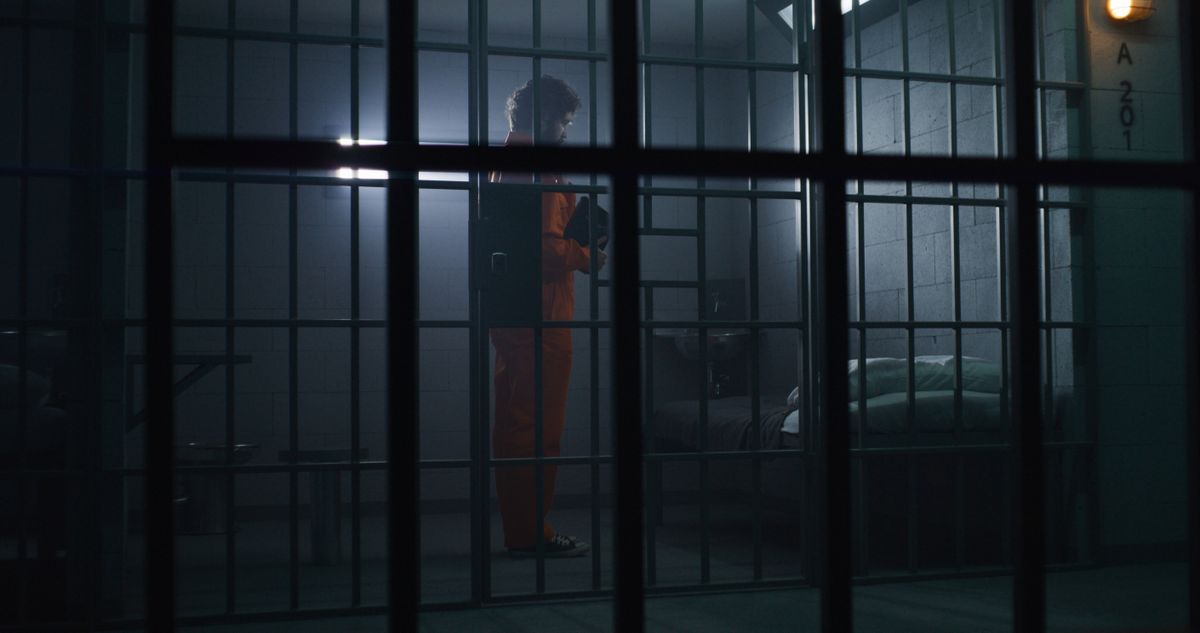 Prisoner,In,Orange,Uniform,Kneels,Near,Bed,,Prays,To,God
Shutterstouck